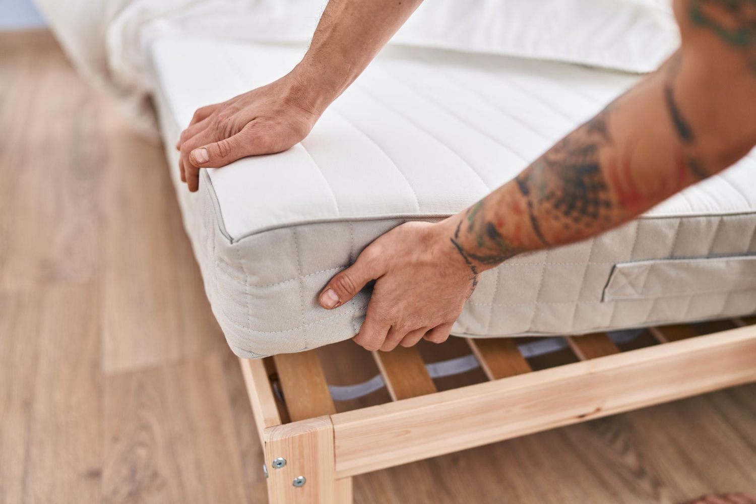 young-man-holding-mattress-bedroom punaises de lit infestation lit
